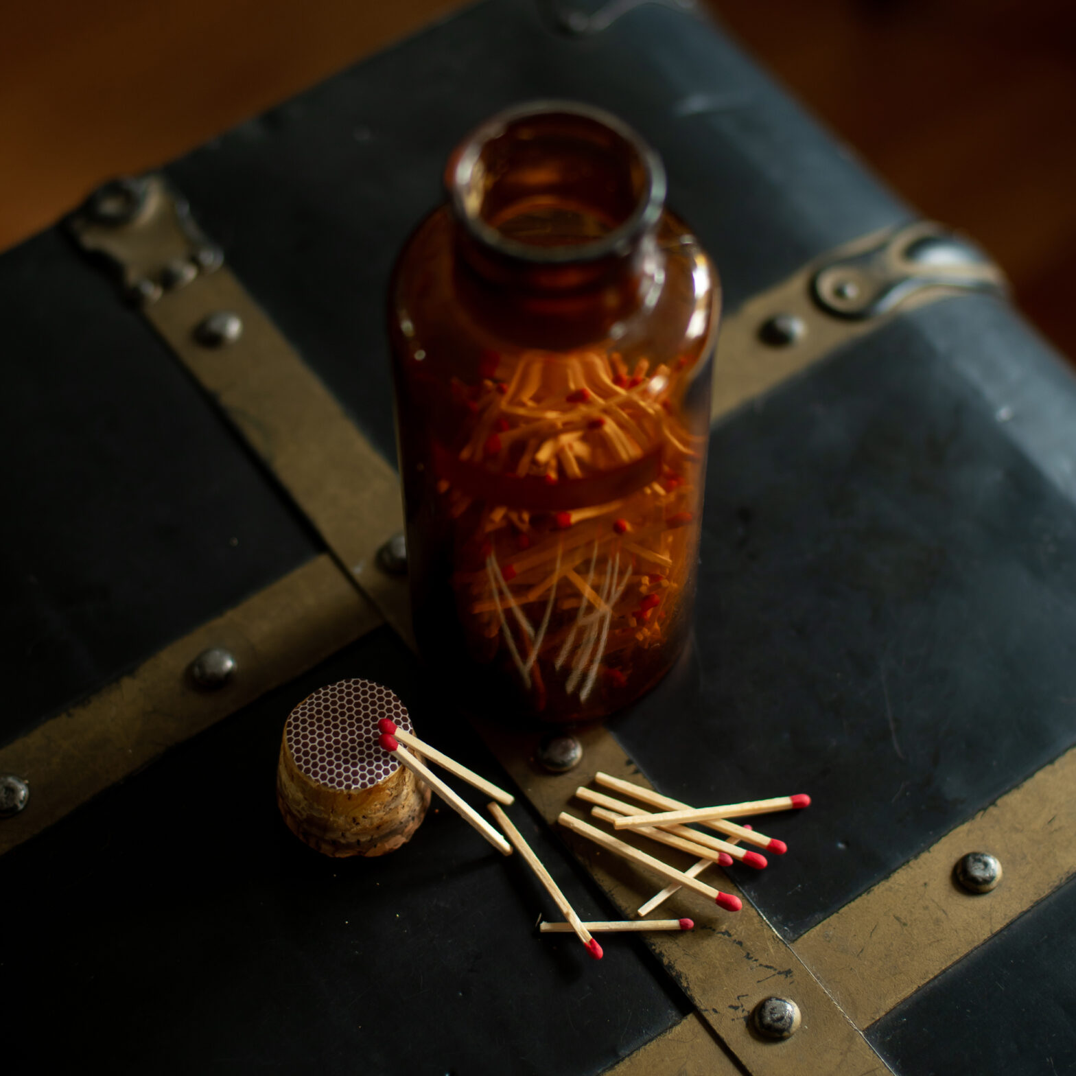 DIY Match Holder with old glass bottle filled with red tipped matches and sticker backed striker paper on the bottle cork.