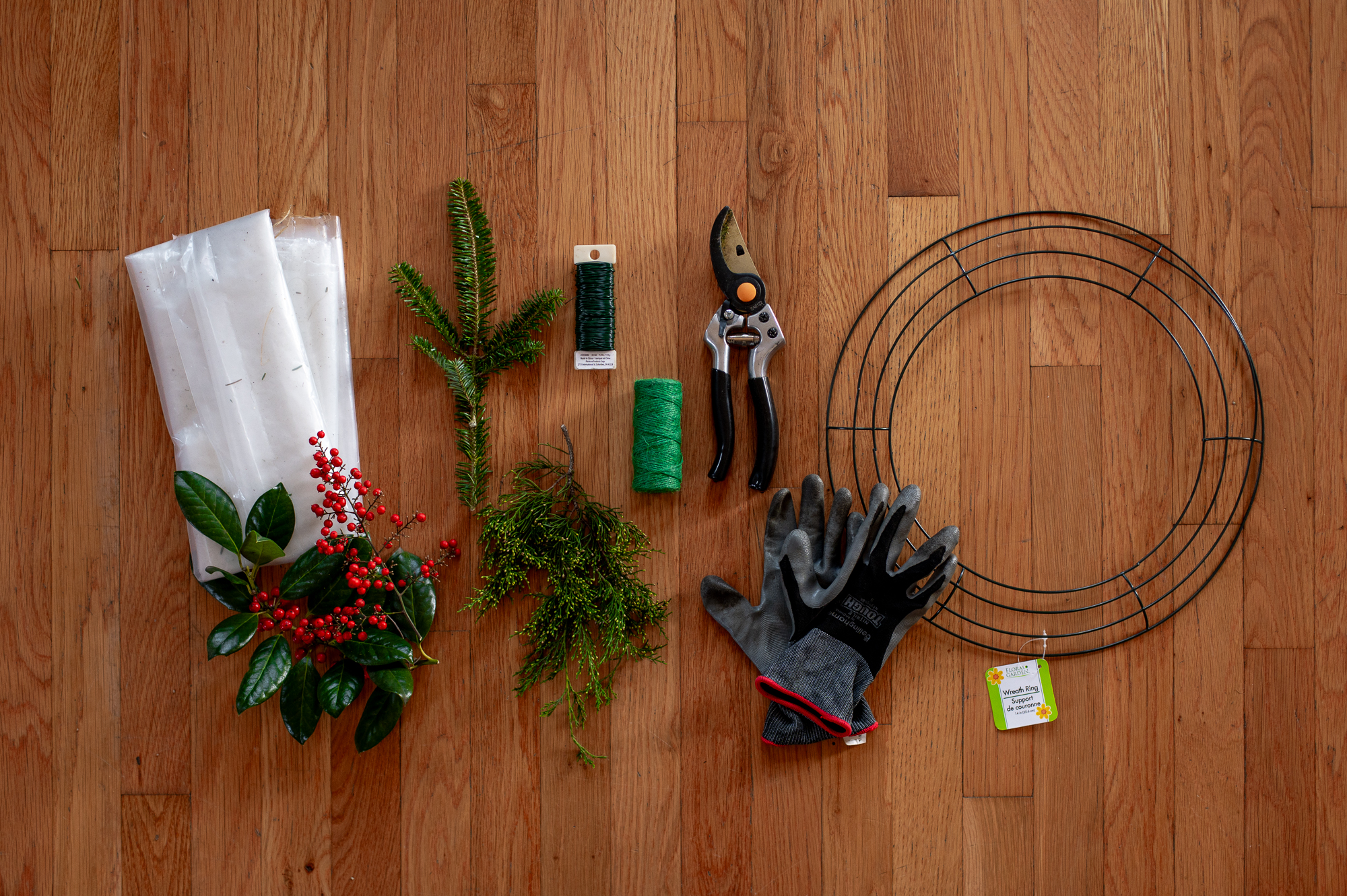 Images showing craft supplies needed for project: plastic sheeting, holly branches, nandina sprigs, fir tree trimmings, juniper tree trimming, floral wire, pruning shears, gloves, a wire wreath form.