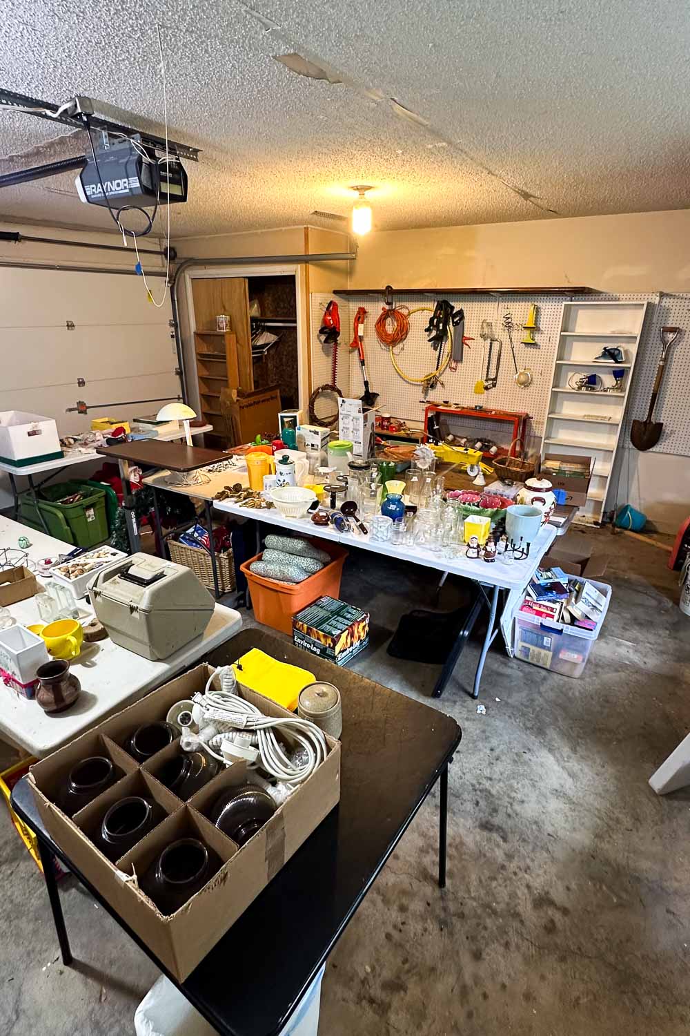 a garage at an estate sale filled with tables displaying home goods