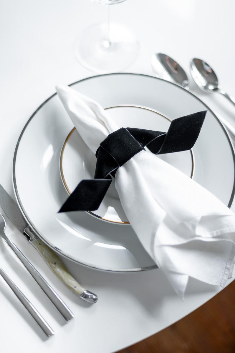 DIY black velvet bat napkin ring on a moody Halloween-inspired tablescape with dark accents.