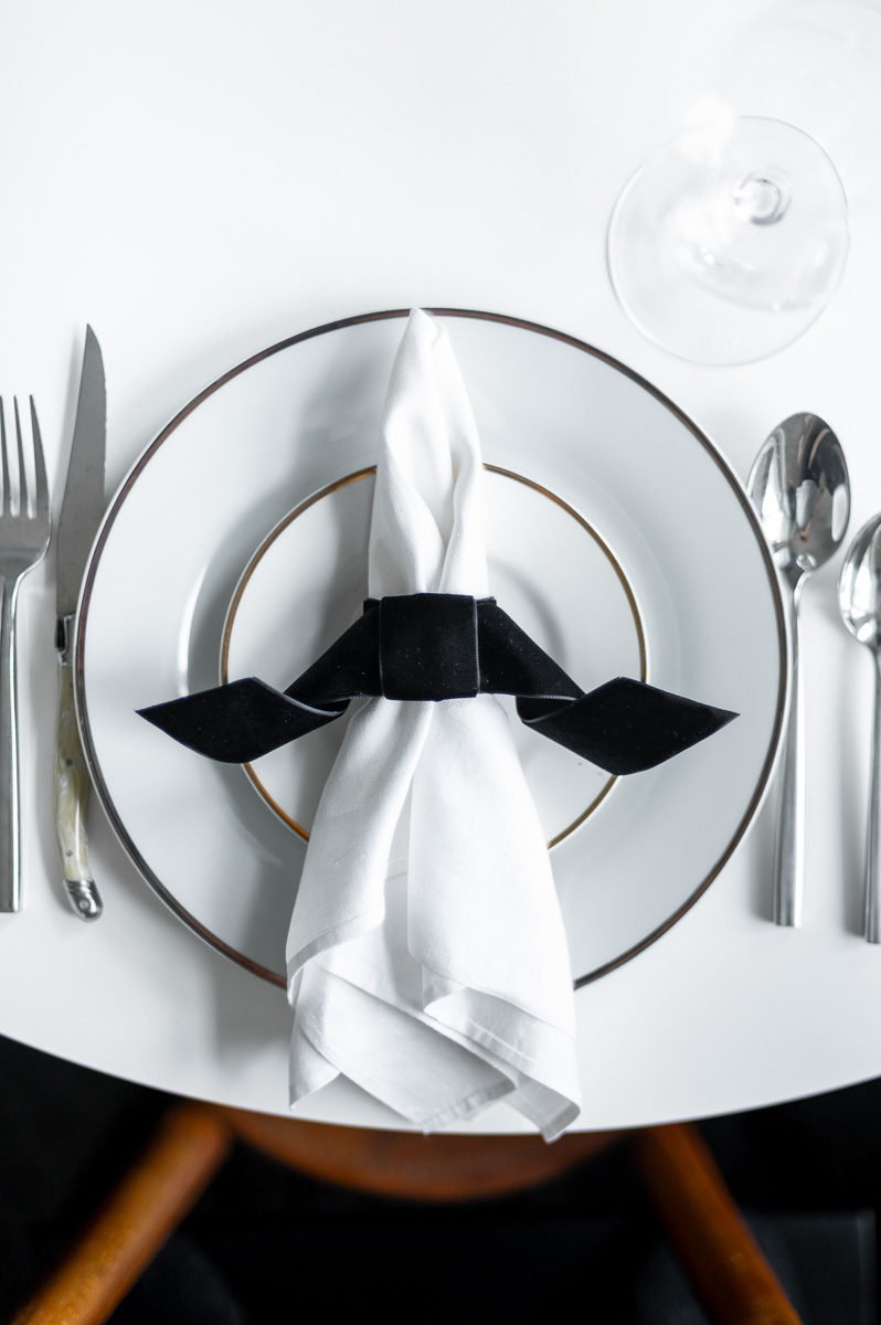 DIY black velvet bat napkin ring on a moody Halloween-inspired tablescape with dark accents.