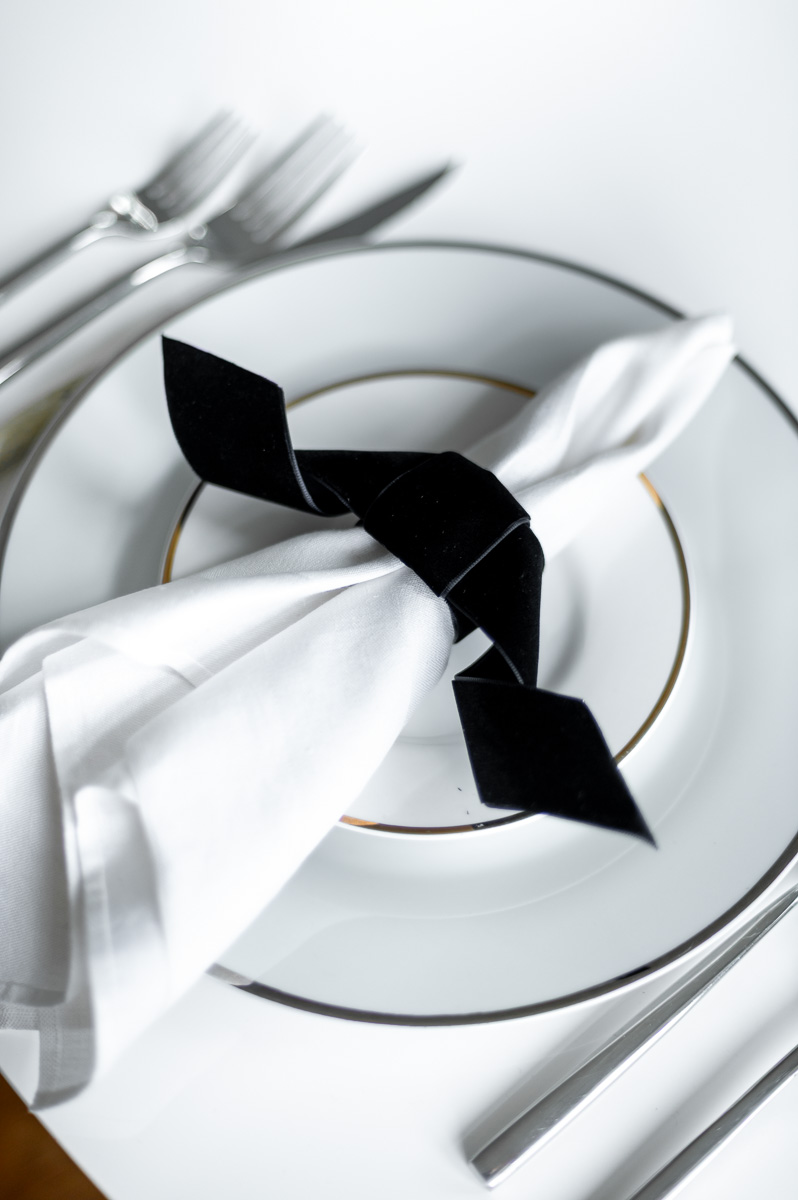 DIY black velvet bat napkin ring on a moody Halloween-inspired tablescape with dark accents.