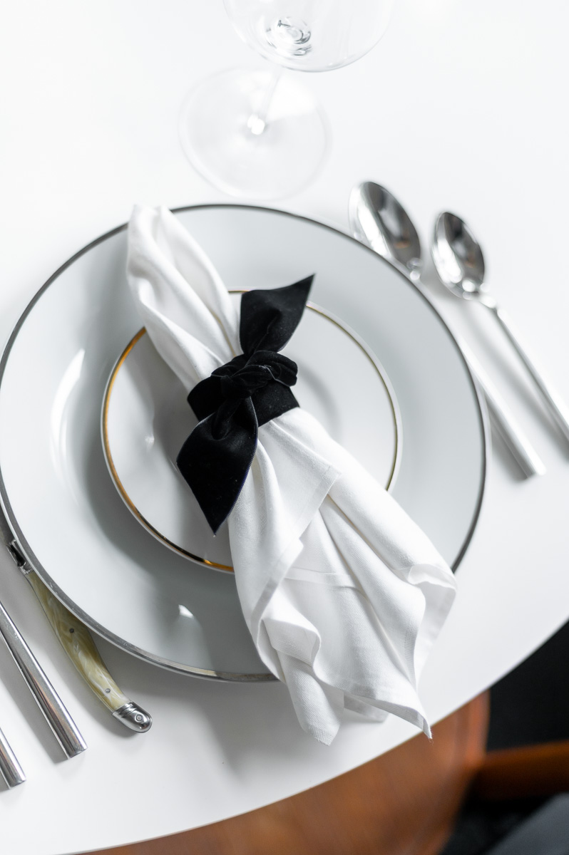DIY black velvet napkin ring on a moody Halloween-inspired tablescape with dark accents.