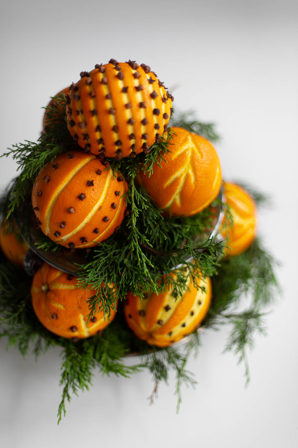 a top view of an orange pomander topiary made from orange clove pomanders and fresh greenery for natural christmas decor