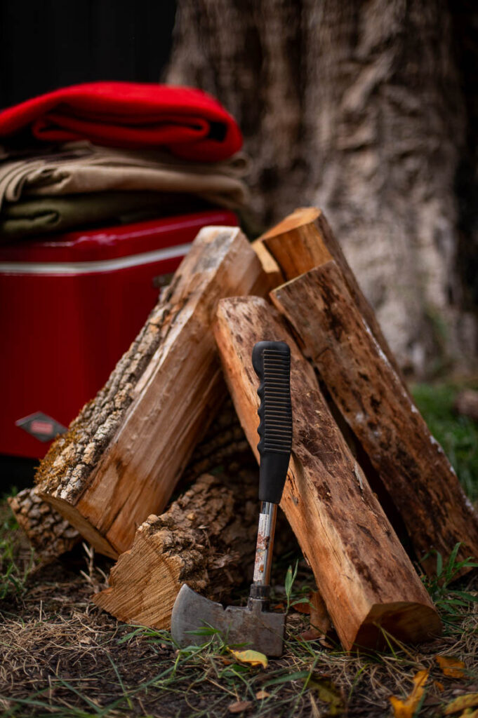 Cozy fire pit party decor with vintage camp gear and plaid blankets – perfect for a fall bonfire night party.