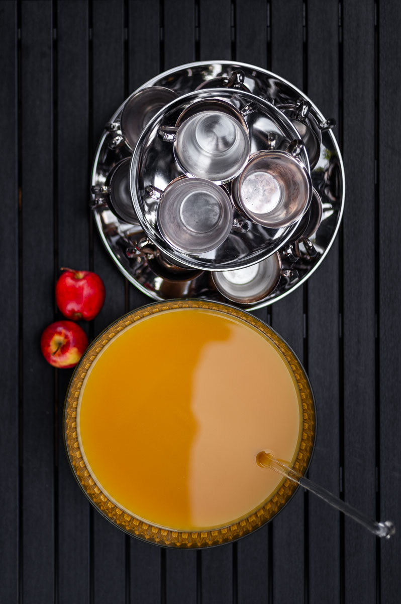 Halloween apple cider punch served in a vintage punch bowl with apples and silver cups, an easy fall punch recipe non alcoholic for parties.
