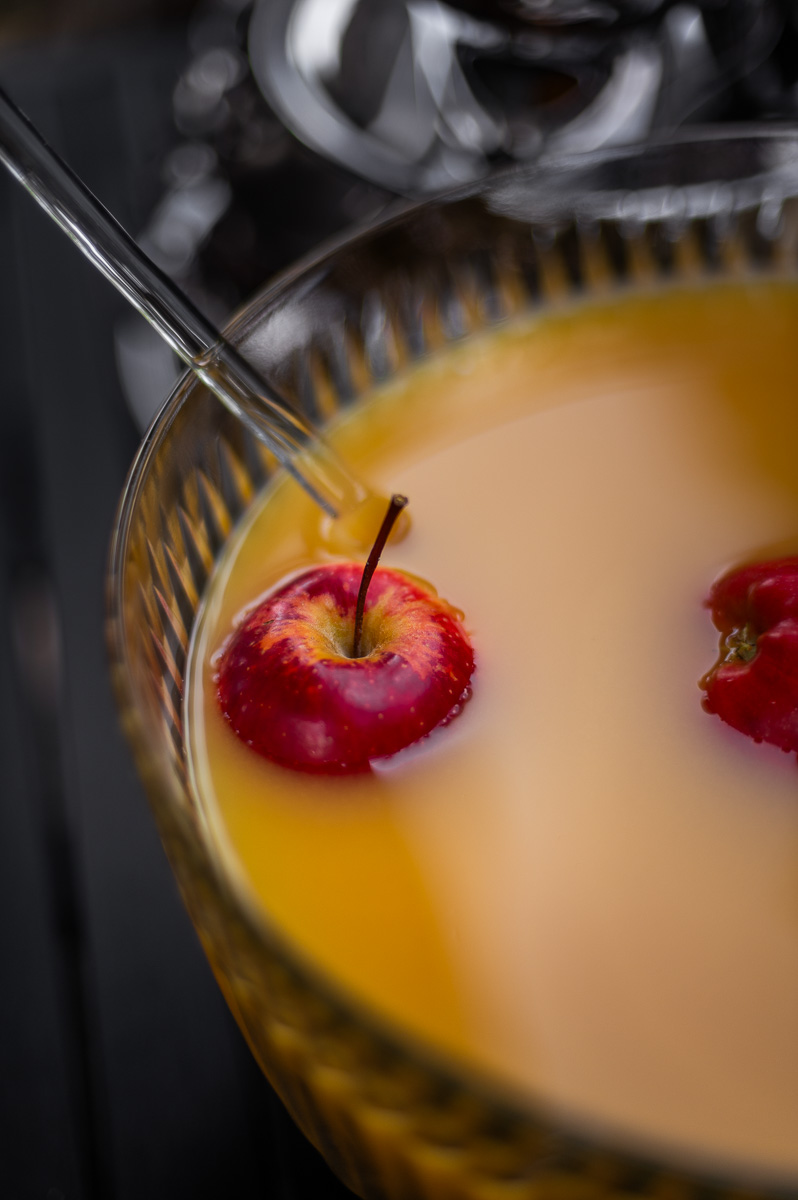 Halloween apple cider punch served in a vintage punch bowl with apples and silver cups, an easy fall punch recipe non alcoholic for parties.