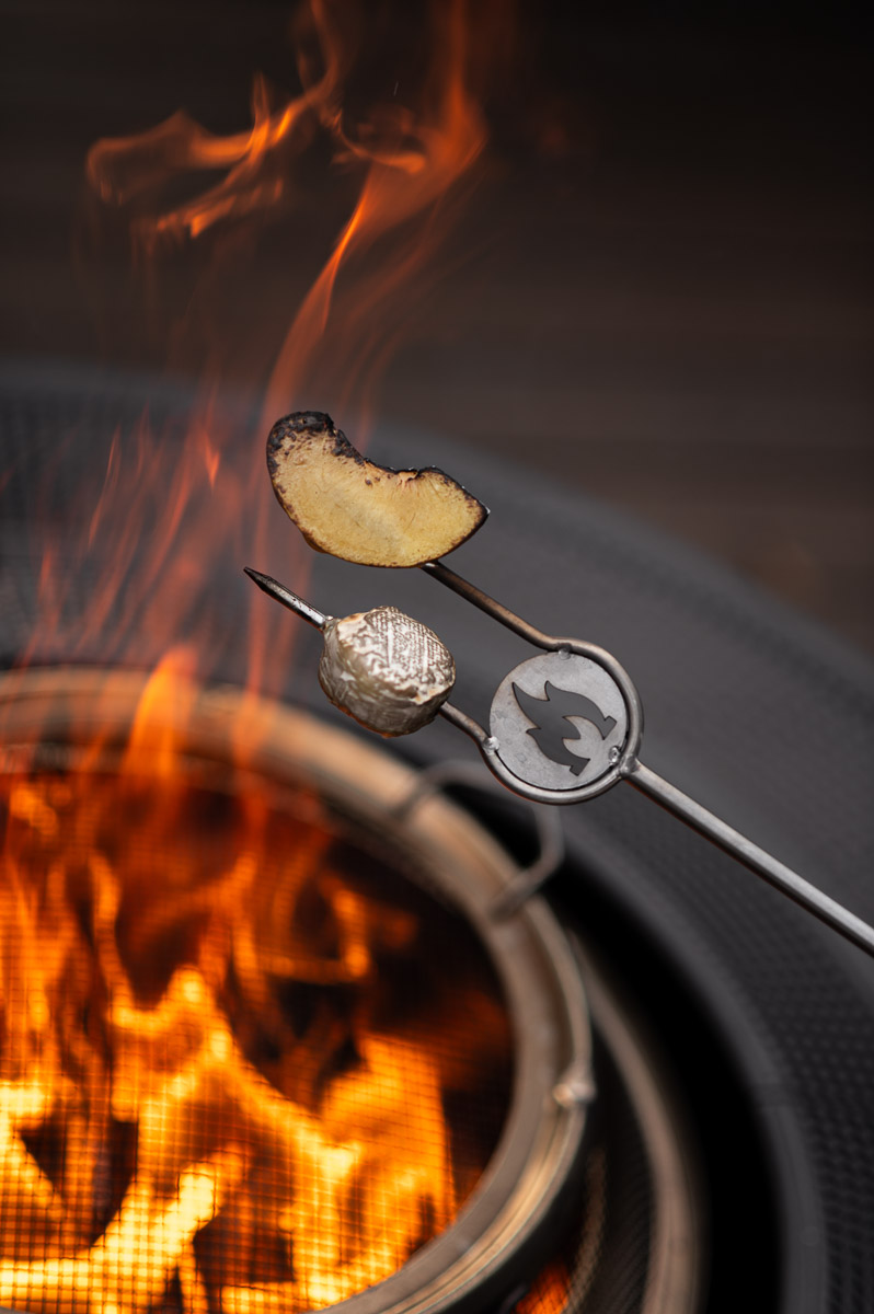 Savory s’mores with brie peach mascarpone and honey being roasted over a solo stove at a backyard s’mores party.