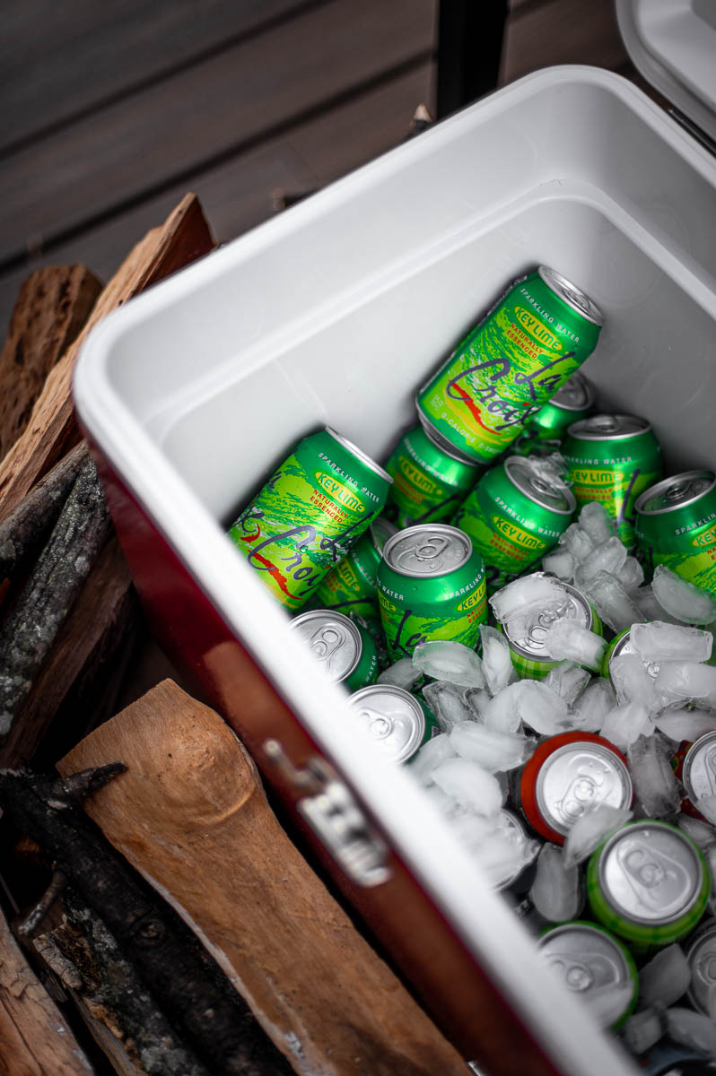 Retro-inspired Coleman cooler stocked with beverages on a cozy fall bonfire night.