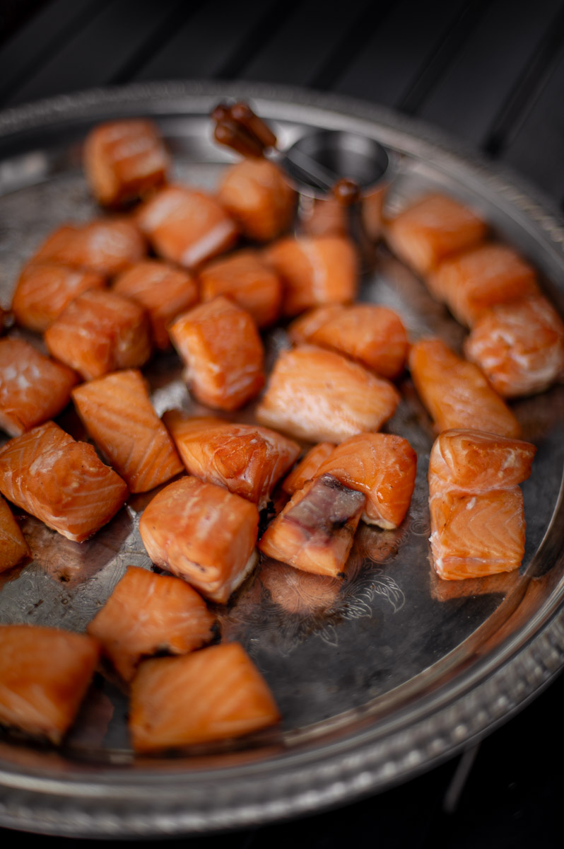 Gourmet smoked salmon bites served on a vintage silver platter for guests at a fall bonfire night party and fire pit gathering.