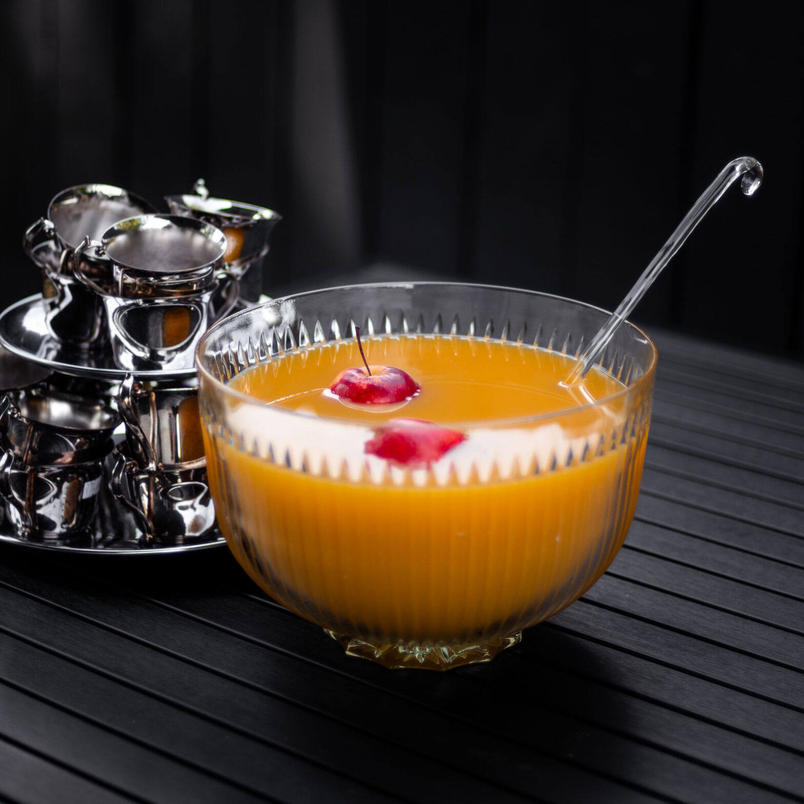 Vintage glass punch bowl filled with apple cider punch non alcoholic, garnished with whole apples and vintage silver punch cups, perfect for a Thanksgiving punch non alcoholic or fall party punch