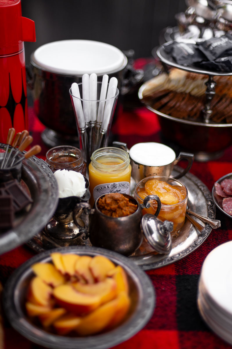 Vintage glass bowls filled with jams, curds, and spreads – unique toppings for a sweet s’mores charcuterie board.