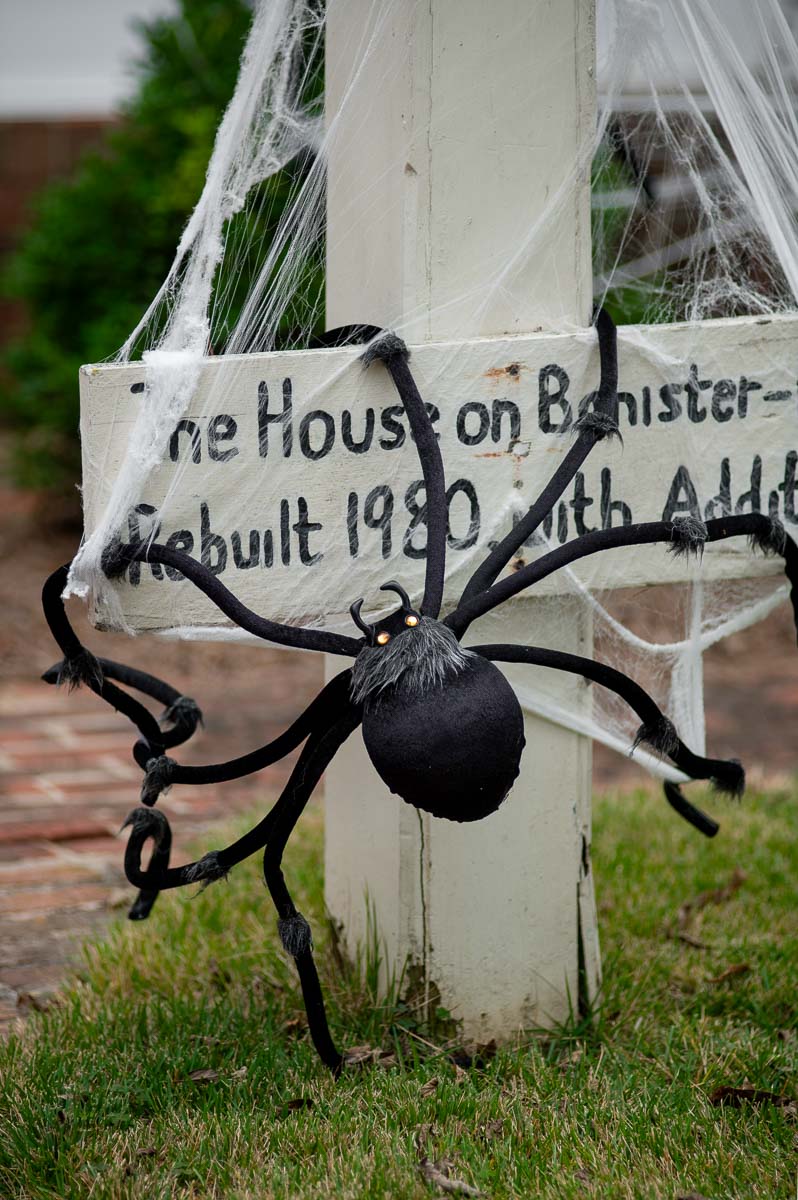 spooky oversized spider and diy spiderweb halloween front yard decorations on a historic home