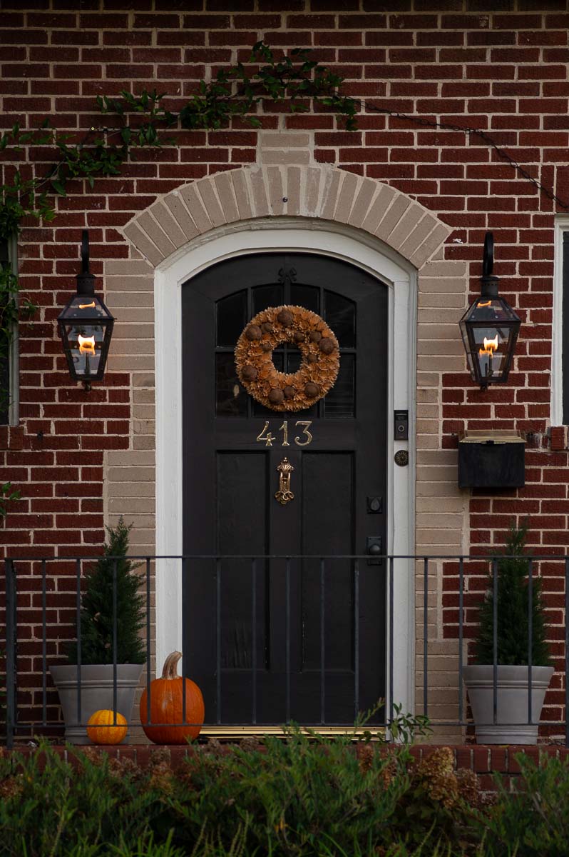 natural wood chip fall wreath for front door with acorns in front of a black door on fall front porch in historic downtown huntsville.