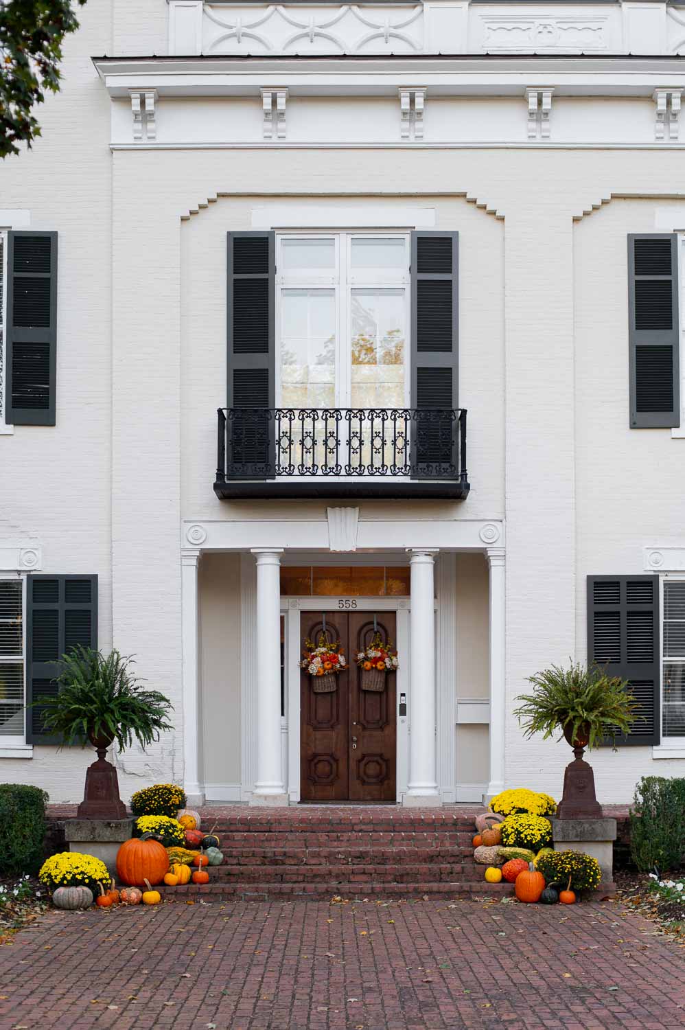 fall front porch decor on a historic southern home showcasing vintage fall urns for front porch
