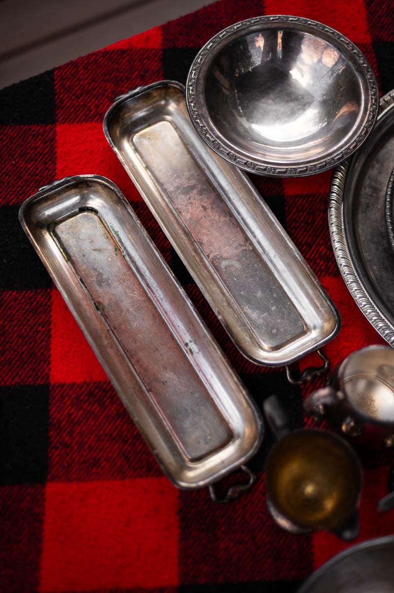 Long skinny silver serving platters displayed on plaid blanket – creative vessels for sweet and savory s’mores ingredients.