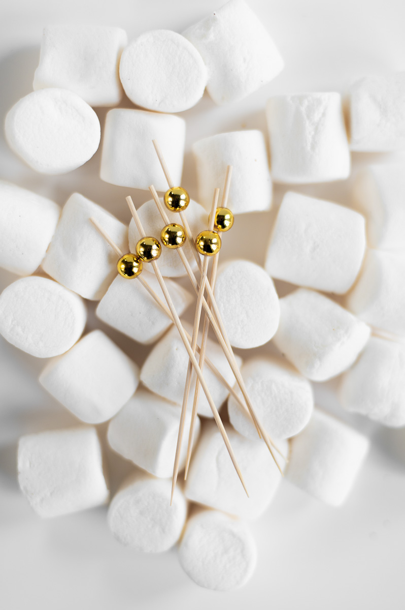 Marshmallows and wooden skewers arranged for assembling individual s’mores cups, a fun summer dessert idea.