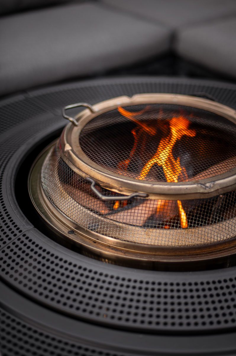 close-up of a glowing fire in a solo stove bonfire fire pit with spark arrestor shield attachment.