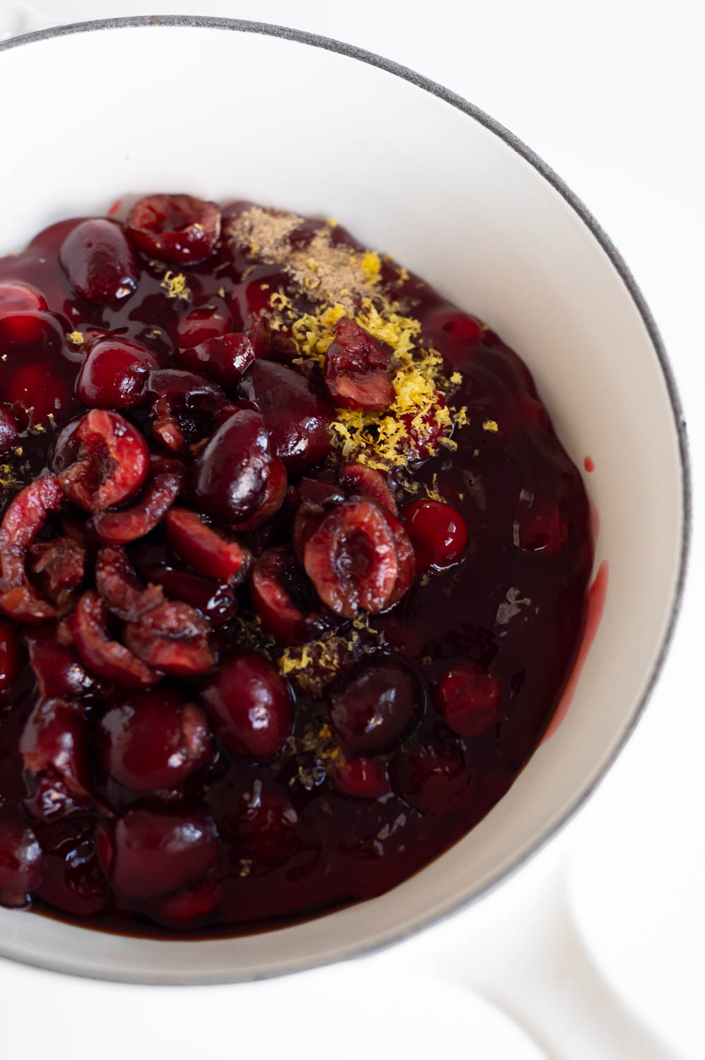 a sauce pan sit on a table filled with canned  pie filling and other ingredients ready for the stove in order to upgrade canned cherry pie filling for semi homemade cherry hand pies