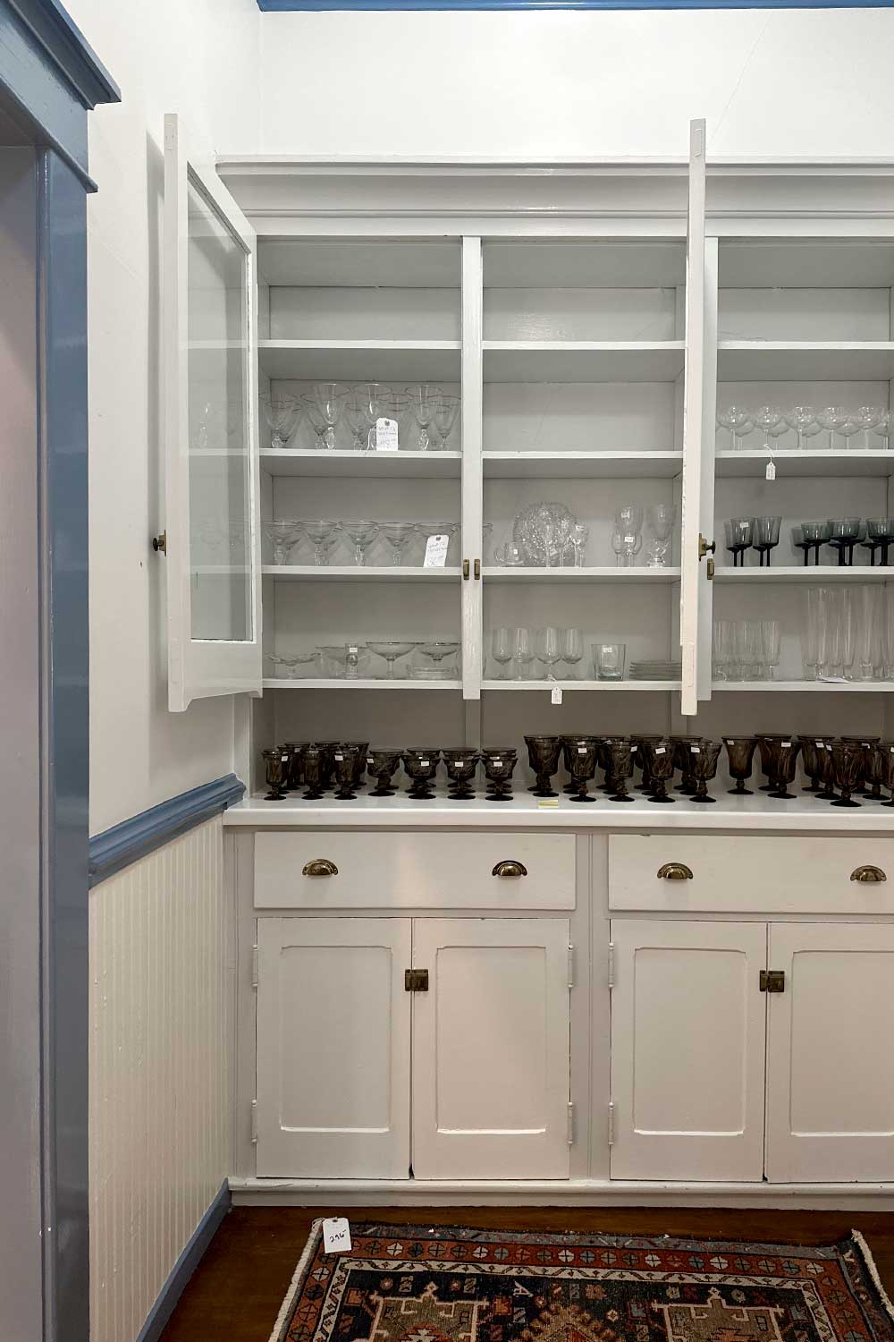 complete sets of vintage glassware in a historic butlers pantry seen while shopping for home decor at an estate sale