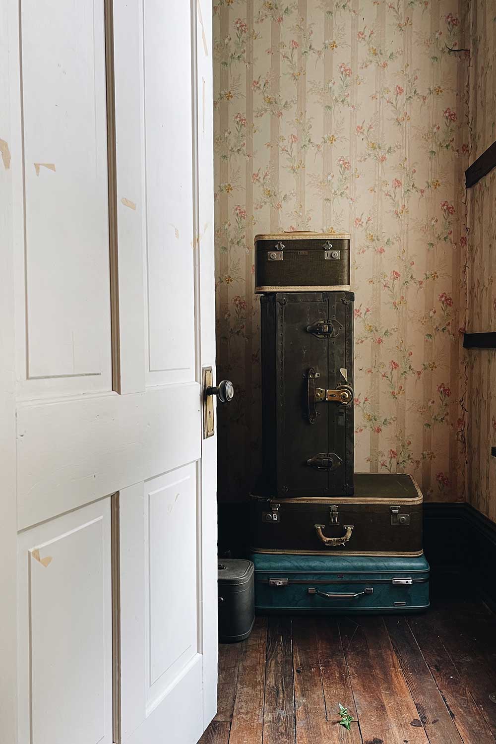 vintage trunks stacked up in a closet in a historic home at an estate sale