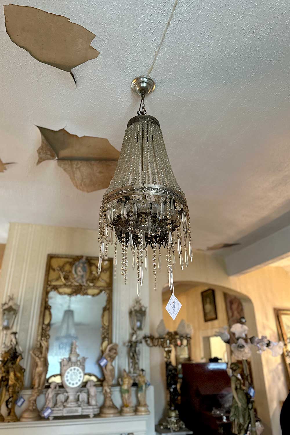 an antique crystal chandelier hangs from the ceiling at a estate sale