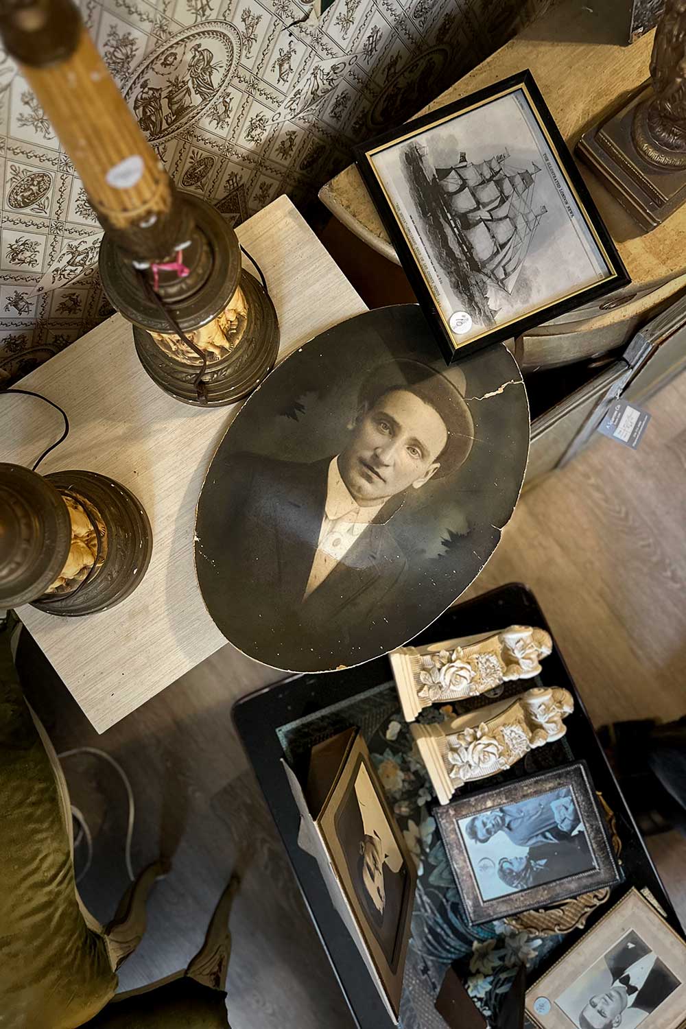 a vintage photograph lays on a table of antique home decor for sale at an estate sale