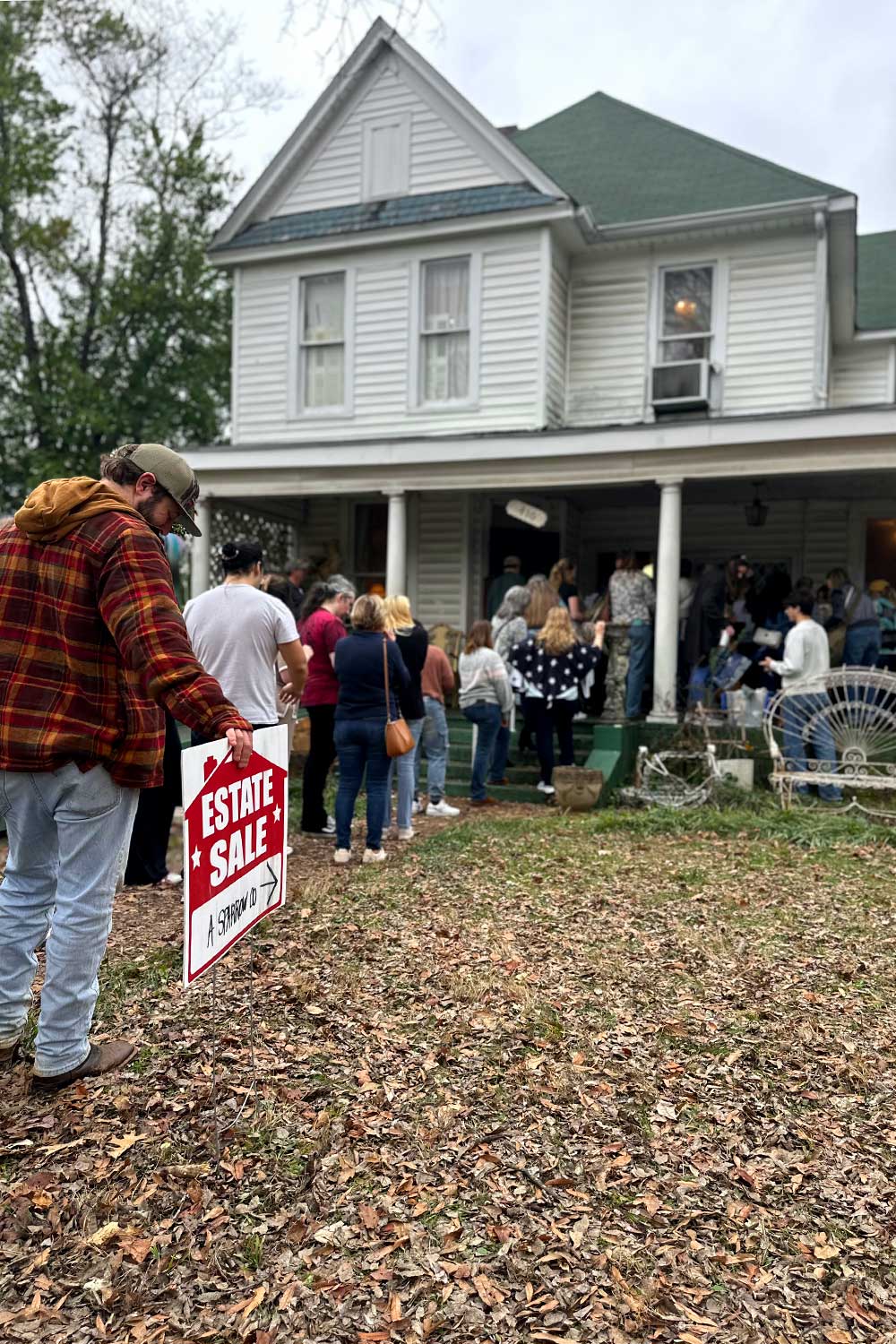 people stand in line waiting to shop an estate sale in a historic home