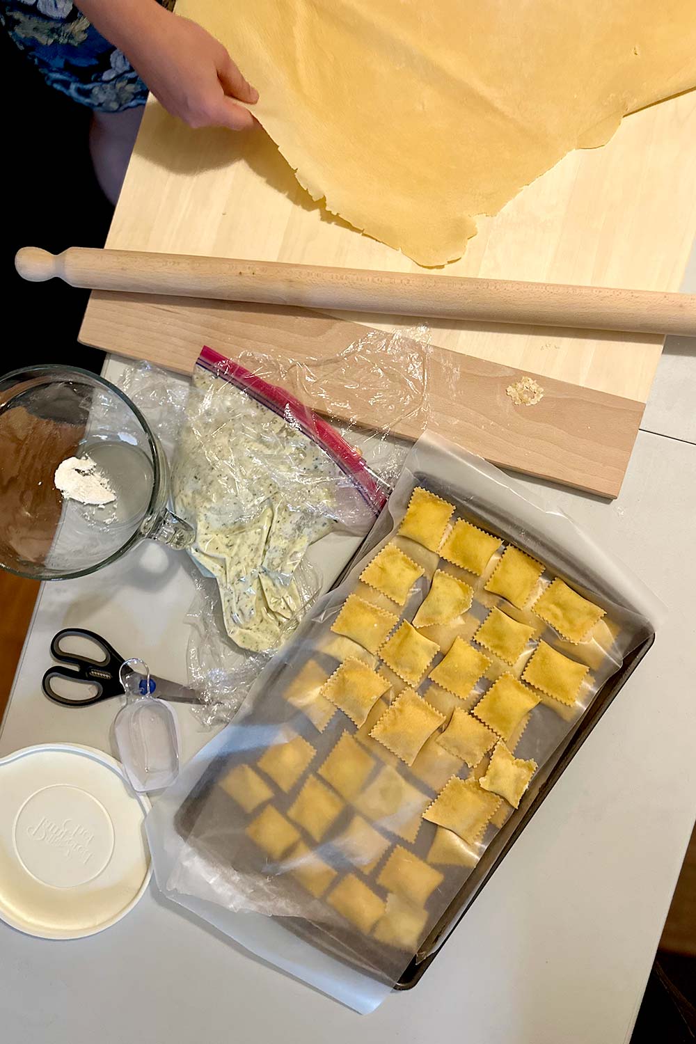 a group of friends making homemade ravioli together at a monthly supper club get together
