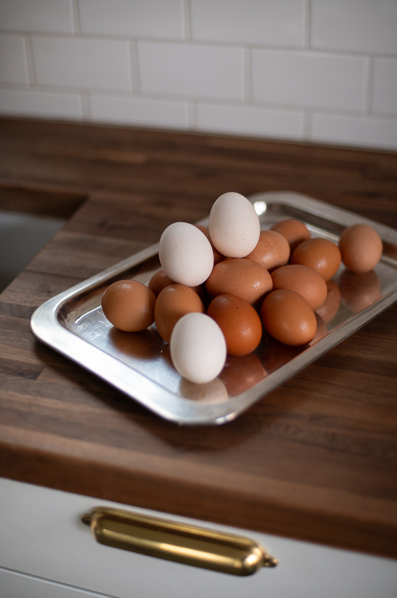Lightened brown eggs turned white for Easter dye sitting on a butcher block counter