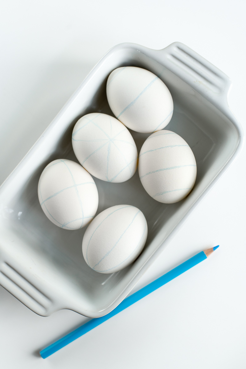 tray of Easter eggs complete with guidelines marked on them ready to decorate for Easter with traditional pysanky Easter egg drop-pull wax designs