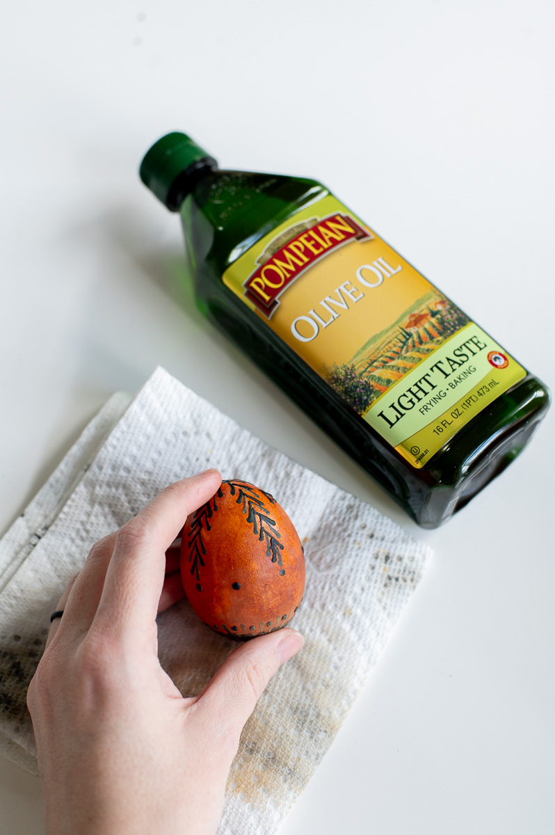 a woman shows an easter egg right after drying out of a dye bath.