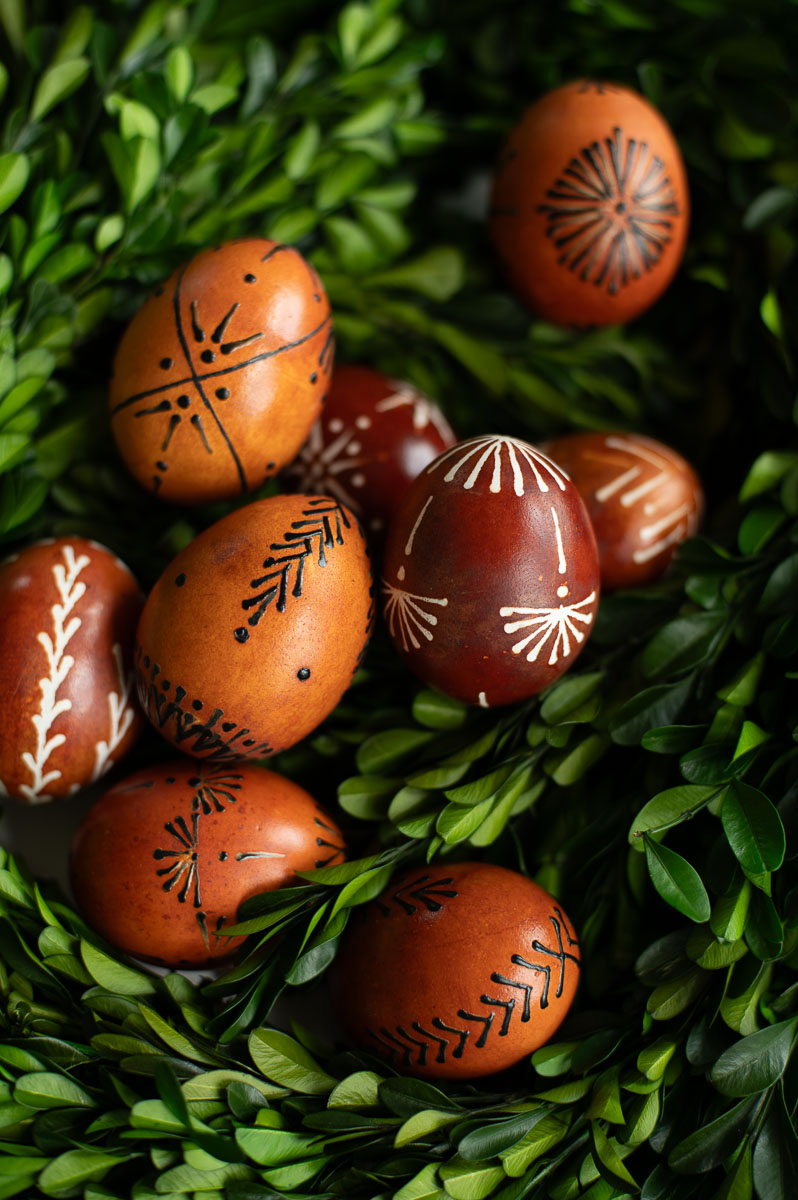 examples of finished eggs decorated with traditional drop-pull, pin-drag easter egg designs and dyed with onion skins.