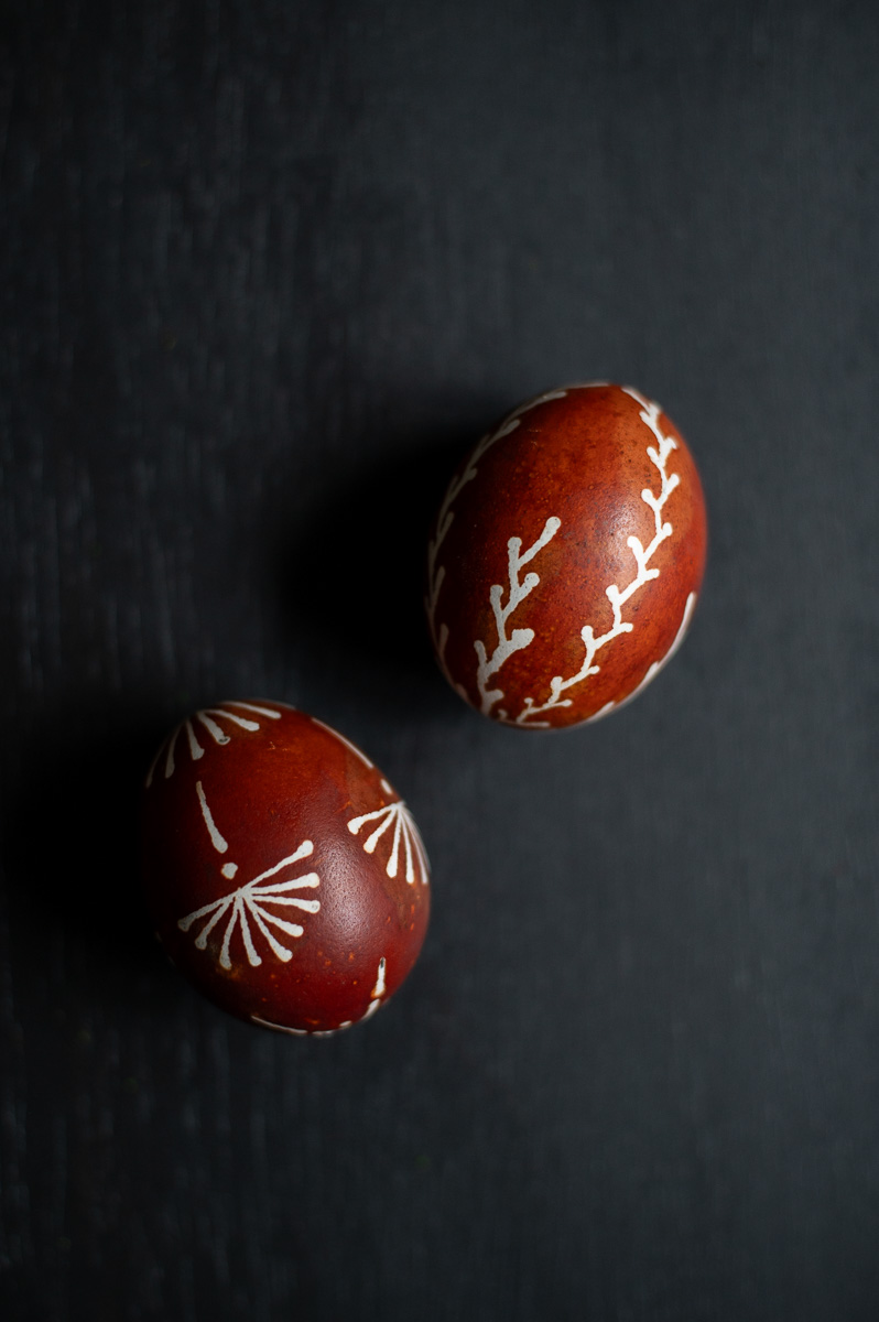 an example of two wax resist eggs dyed with onion skins using traditional drop-pull, pin-drag pysanky wax techniques.