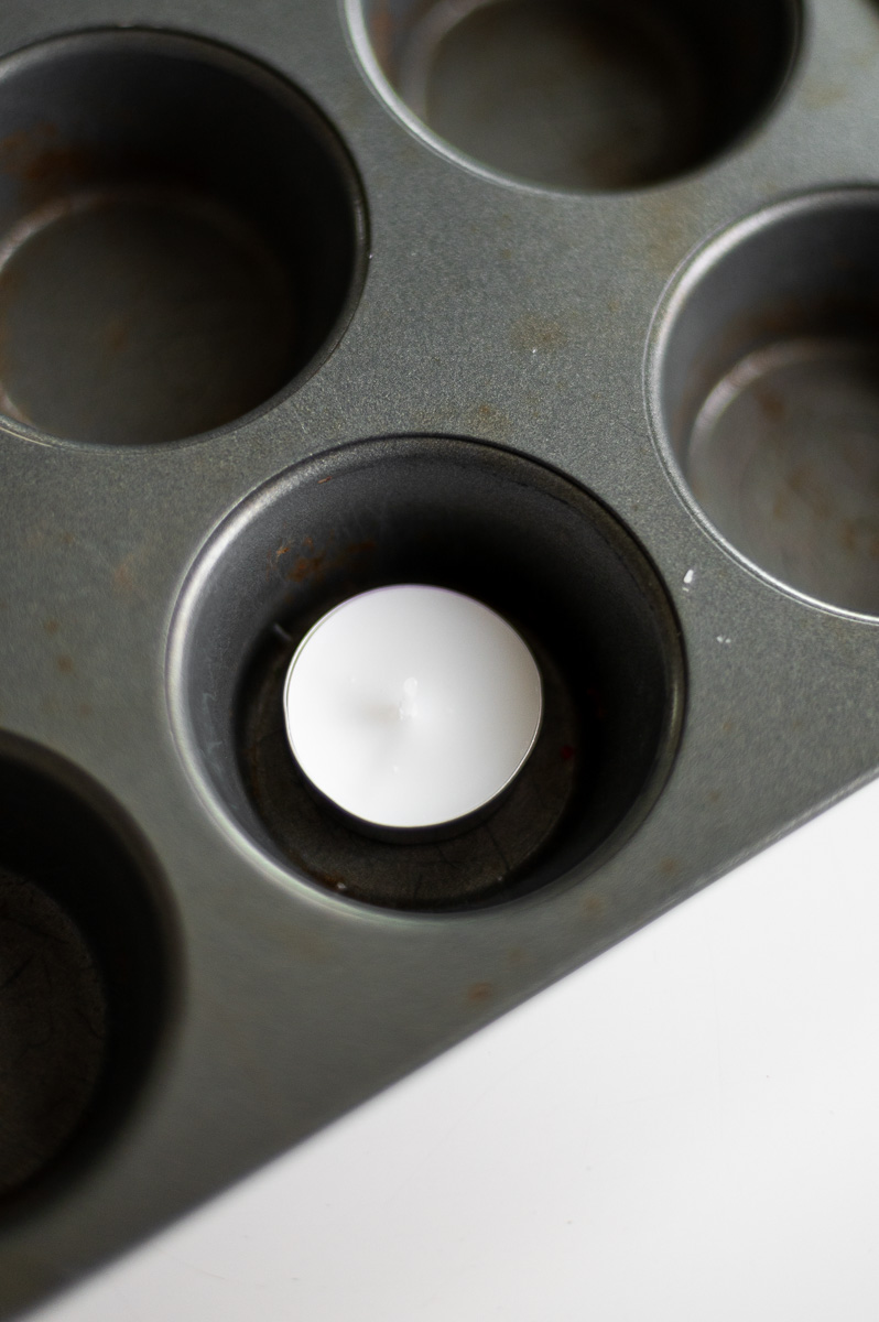 how to make an improvised wax warmer with a muffin tin, tea light, wire cooling rack and old spent tea light cup.