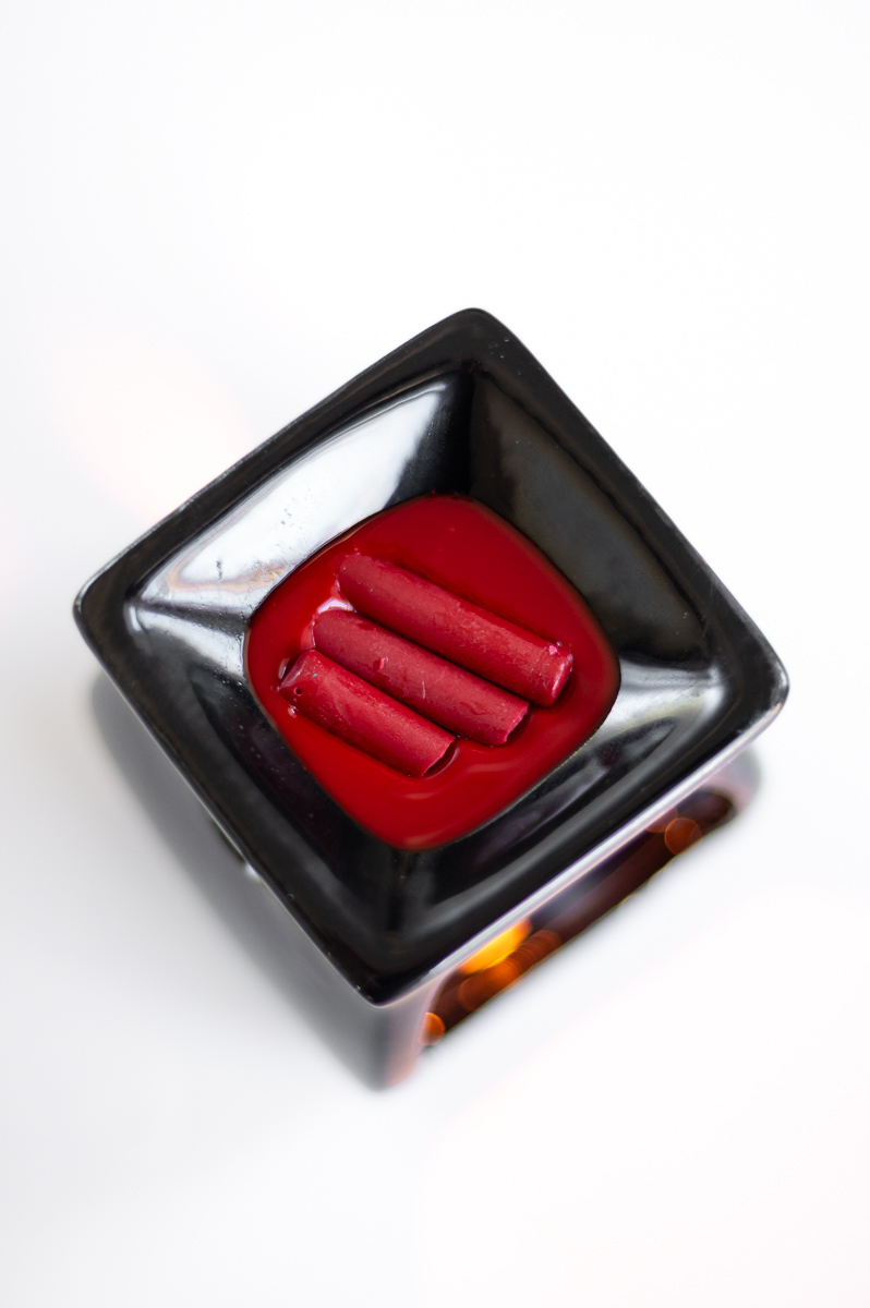 red crayon wax melts in a fragrance warmer from the dollar tree in preparation for creating drop-pull wax Easter eggs designs to create Pysanky without a kistka